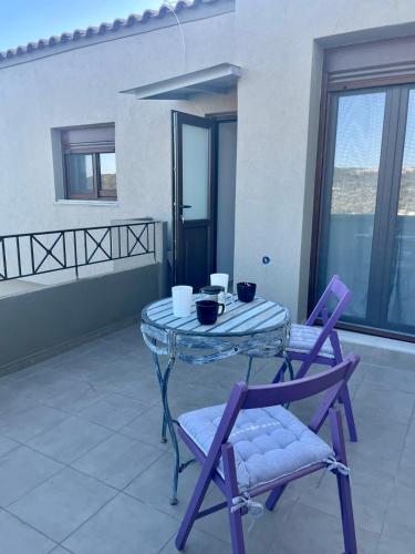 a glass table and two chairs on a patio at Sky view in Taxiárkhai