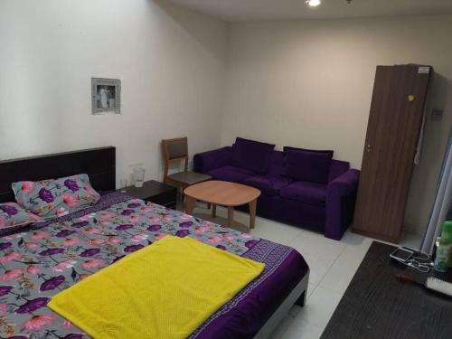 a bedroom with a bed and a purple couch at Lovely 2Bhk Family Apartment in Ajman in Al Ḩamīdīyah