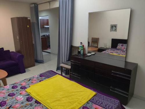 a bedroom with a dresser and a large mirror at Lovely 2Bhk Family Apartment in Ajman in Al Ḩamīdīyah