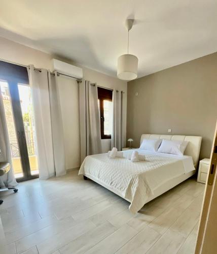 a bedroom with a white bed and a large window at Sky view in Taxiárkhai