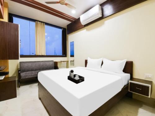 una camera con un grande letto bianco e una sedia di Hotel Mohiraj a Bankipur