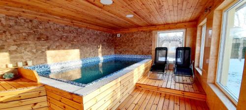 Līči的住宿－RelaxRitual，一座带两把椅子的木屋内的游泳池
