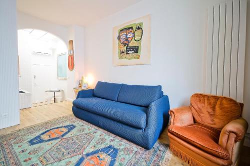 a living room with a blue couch and a chair at 2 pièces à Bastille in Paris