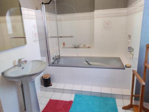 a bathroom with a tub and a sink at LA TAILLANDERIE 