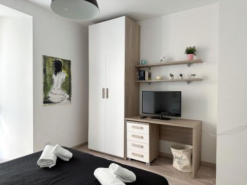 a bedroom with a bed and a tv on a desk at Ca Belverz center town apartment in Bellagio