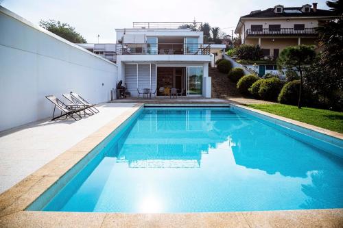 a swimming pool in front of a house at Casa da Barra in Vila Nova de Gaia