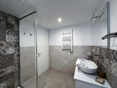 un bagno con doccia in vetro e lavandino di Dimora Romantica apartment a Bellagio