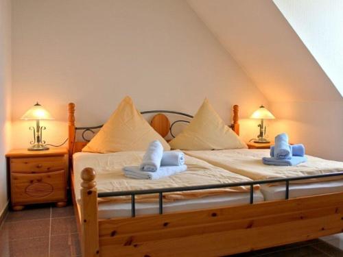 ein Schlafzimmer mit einem Bett mit Handtüchern und zwei Lampen in der Unterkunft Fewo auf Wassergrundstück in Malchow