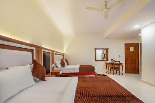 um quarto com uma cama grande e uma mesa em Hotel South Indian em Nova Deli