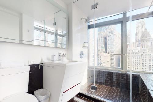 a bathroom with a toilet and a shower with a window at Blueground Tribeca roof deck nr WTC NYC-1377 in New York