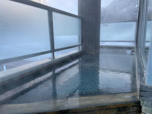 a balcony with a fence and a pool of water at フューデイズコンドミニアム定山渓　302号室 in Jozankei