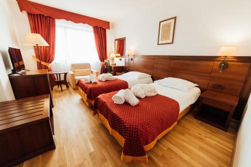 a hotel room with two beds with towels on them at Hotel Picok in Ðurđevac
