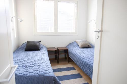 a bedroom with two beds and a window at Kaisantien Siiri in Kajaani