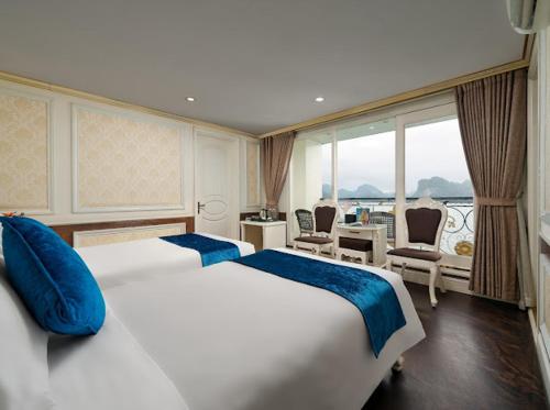 a hotel room with two beds and a balcony at La Renta Premium Cruise in Ha Long