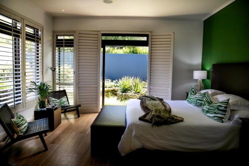 1 dormitorio con 1 cama con pared verde en Selkirk House en Hermanus