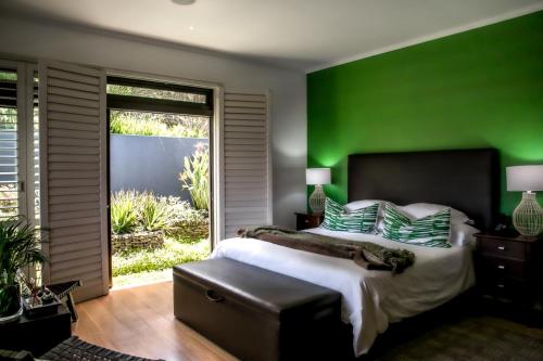 a bedroom with green walls and a large bed at Selkirk House in Hermanus