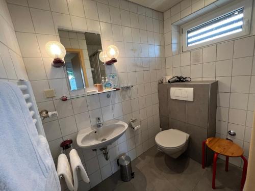 a white bathroom with a sink and a toilet at Hotel Pension Heidi in Dobel
