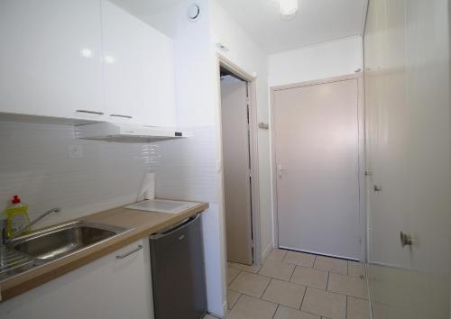 - une cuisine blanche avec un évier et une douche dans l'établissement Studio 4 personnes a 600m de la plage et parking, à Canet