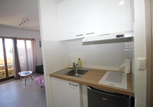 une cuisine avec un évier et un plan de travail dans l'établissement Studio 4 personnes a 600m de la plage et parking, à Canet