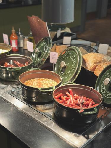 a buffet with bowls of food on a counter at Comfort Hotel Kristiansand in Kristiansand