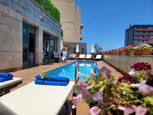 a woman standing on the roof of a building with a swimming pool at Sky Suites in Beirut