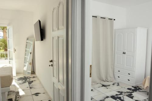 a bathroom with a white door and a tiled floor at Aegean White Aparts in Naxos Chora