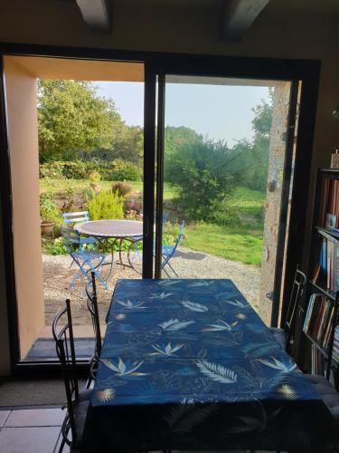 een kamer met een bed, een tafel en een raam bij la balinade in Riantec