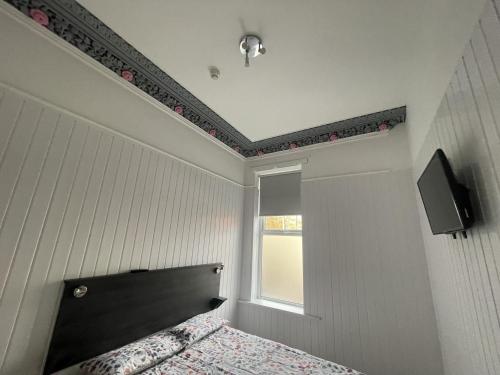 een slaapkamer met een bed met een zwart hoofdeinde en een raam bij OYO Queens Quarter in Belfast