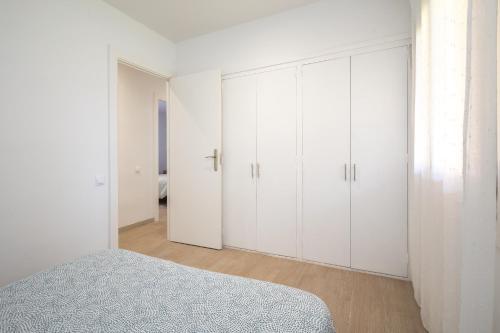 a white bedroom with white cabinets and a bed at La Caseta de Sant Pol in Sant Feliu de Guixols