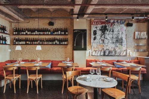 a restaurant with tables and chairs and a red couch at Hotel Casa Bonay & Spa in Barcelona