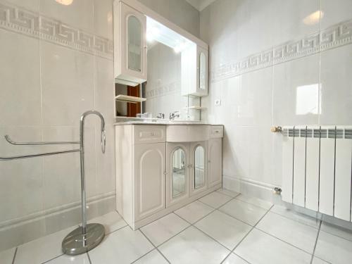 a white bathroom with a sink and a shower at Holiday House Praia D Ana in Lagos