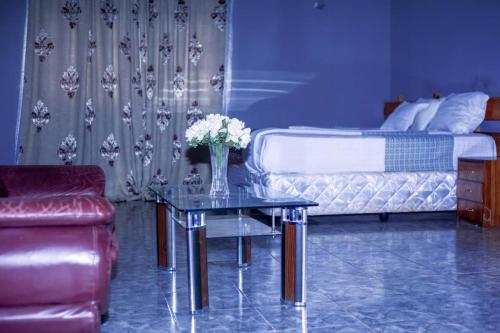 - une chambre avec un lit et une table fleurie dans l'établissement White Lotus Lodges Katete, à Chongwe