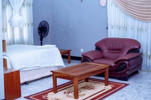 ChongweにあるWhite Lotus Lodges Kateteのベッドルーム(ソファ、椅子、ベッド付)