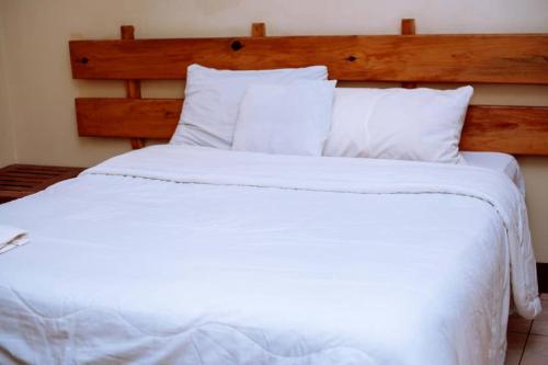 a large white bed with white sheets and pillows at White Lotus Lodges Katete in Chongwe