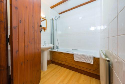 Deanwood Holiday Cottages في Yorkley: حمام مع حوض استحمام ومغسلة