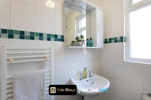 a white bathroom with a sink and a mirror at 87 Allesley Old Road By Oak Stays Short Lets & Serviced Accommodation Leicester Coventry With Free Parking in Coventry