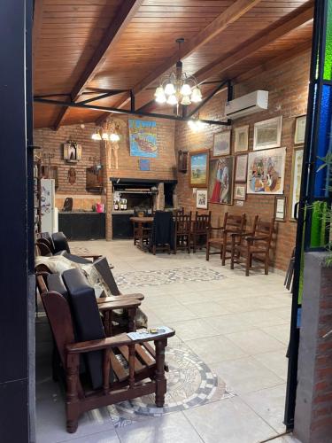 a room with chairs and tables and a fireplace at Quincho por dia in Corrientes