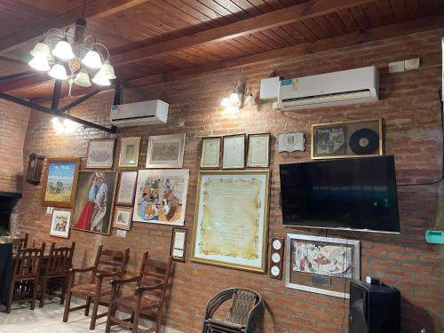 a brick wall with a television and pictures on it at Quincho por dia in Corrientes