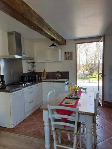 une cuisine avec une table en bois et une salle à manger dans l'établissement L' Epi de Blé, à Lacres