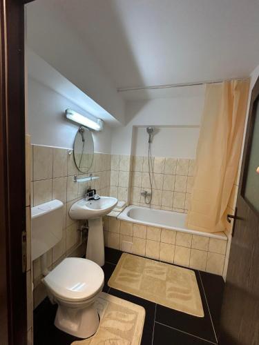 a bathroom with a toilet and a sink and a tub at Apartament de 3 camere zona Obcini in Suceava