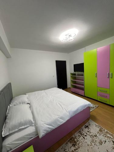 1 dormitorio con 1 cama y armario verde y morado en Apartament de 3 camere zona Obcini, en Suceava