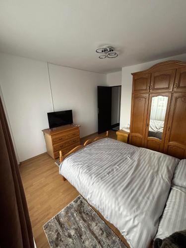 a bedroom with a bed and a dresser and a television at Apartament de 3 camere zona Obcini in Suceava