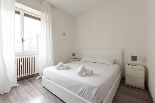 Large Apartment Close to Metro في ميلانو: غرفة نوم بيضاء مع سرير أبيض كبير مع وسائد بيضاء