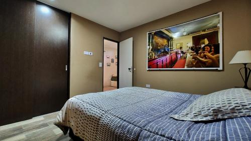 1 dormitorio con 1 cama con una foto en la pared en Las margaritas en Uspallata