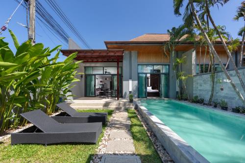 a villa with a swimming pool and a house at Onyx Villas by TropicLook in Nai Harn Beach