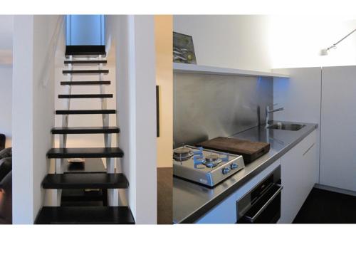 a kitchen with a staircase and a stove and a sink at Pescallo Apartments in Bellagio