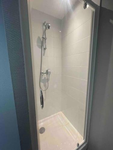 une douche avec une porte vitrée dans une salle de bain dans l'établissement Studio 4 cœur de ville, à Besançon
