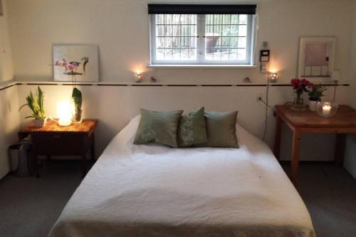 - une chambre avec un grand lit blanc et une fenêtre dans l'établissement Copenhagen Open Plan House in Hellerup, à Hellerup