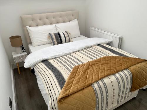 a bedroom with a large bed with white sheets and pillows at Charming 1 bedroom Apartment In The Heart Of Manchester Close to Manchester City Centre And Etihad Stadium in Manchester