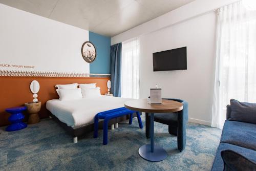 une chambre d'hôtel avec un lit, une table et un canapé dans l'établissement The Ruck Hotel, à Lyon
